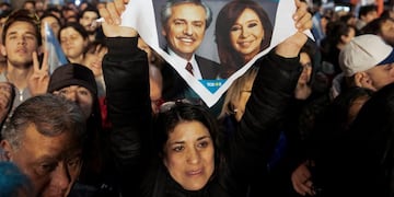 A supporter of presidential candidate Alberto Fernandez holds up a handkerchief with photos of him and his running-mate, former President Cristina Fernandez, outside the \