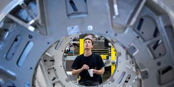 An employee fixes barcode labels to the gantry of a Siemens Somatom computerized tomography (CT) scanner machine on the assembly line at the Siemens AG Healthineers factory in Forchheim, Germany, on Wednesday, July 19, 2017\u002E Siemens said it's moving ahead with a planned split from its health-care division as Europe's largest engineering company whittles down its core holdings to focus on energy and factory equipment\u002E Photographer: Krisztian Bocsi/Bloomberg alemania Forchheim fabrica de siemens en Forchheim alemania produccion tomografo computado tomografia computada tecnologia equipamiento para la salud