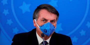 (FILES) In this file photo taken on March 20, 2020 Brazil's President Jair Bolsonaro wears a face mask during a press conference on the coronavirus pandemic COVID-19 at the Planalto Palace in Brasilia\u002E - Brazil's COVID-19 death toll passed 15,000 on May 16, 2020, official figures showed, while its number of infections topped 230,000, making it the country with the fifth highest number of cases in the world\u002E (Photo by Sergio LIMA / AFP)