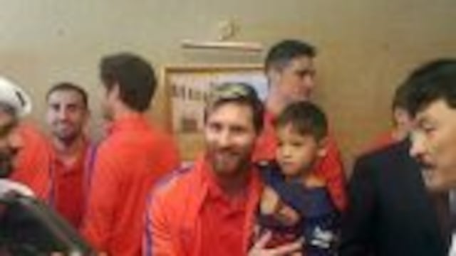 A handout picture released by Qataru2019s Supreme Committee for Delivery and Legacy on December 13, 2016 shows Barcelona's Argentinian forward Lionel Messi (C-L) holding six-year-old Afghan boy Murtaza Ahmadi (C-R) in Doha, upon the team's arrival to play a f