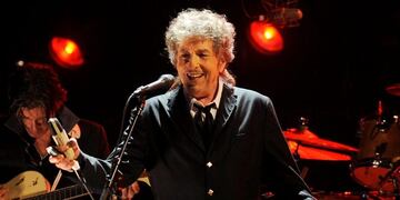 FILE - In this Jan. 12, 2012, file photo, Bob Dylan performs in Los Angeles. Dylan, who was named the winner of the 2016 Nobel Prize in literature on Oct. 13, 2016, says he u201cabsolutelyu201d wants to attend the Nobel Prize Award Ceremony u201cif itu2019s at all possibleu201d in December, finally breaking his silence about earning the prestigious honor. (AP Photo/Chris Pizzello, File)