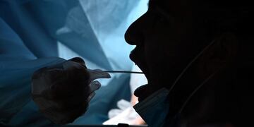 TOPSHOT - A healthcare worker collects a test sample from a motorist at a drive-through coronavirus (Covid-19) testing center at M\u002ET\u002EO\u002E Shahmaghsoudi School of Islamic Sufism on September 29, 2020 in Los Angeles, California\u002E (Photo by Robyn Beck / AFP)