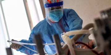 A medical staff member treats a patient infected by the COVID-19 coronavirus at Red Cross Hospital in Wuhan in China's central Hubei province on March 10, 2020\u002E - Chinese President Xi Jinping said on March 10 that Wuhan has turned the tide against the deadly coronavirus outbreak, as he paid his first visit to the city at the heart of the global epidemic\u002E (Photo by STR / AFP) / China OUT