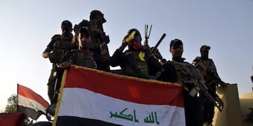 EBAG11\u002E Mosul (Iraq)\u002E- (FILE) - Iraqi soldiers hold up the Iraqi national flag in central Mosul, northern Iraq, 10 July 2017 (reissued 09 December 2017)\u002E Iraqi Prime Minister Haidar al-Abadi on 09 December 2017 announced the remaining Iraqi region under Islamic state control, nearby the Iraqi border with Syria was now under complete control of Iraq's armed forces, putting to an end its war against the so-called Islamic State\u002E (Siria) EFE/EPA/STR *** Local Caption *** 53640127