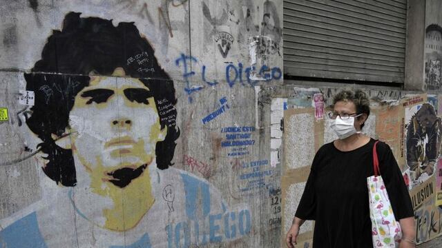 Una mujer camina junto a un mural de Diego Maradona (Foto: JUAN MABROMATA / AFP)