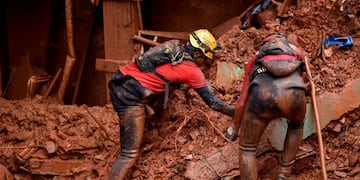 Firefighters search for missing persons after a landslide in Vila Bernadete, Belo Horizonte, Minas Gerais state, Brazil, on January 26, 2020\u002E - A landslide buried several houses in Vila Bernadete Friday, leaving 4 dead and 7 missing\u002E Two days of torrential rains in Minas Gerais state have left at least 30 people killed, several injured, 17 missing and more than 2,500 homeless following a series of landslides and house collapses, Civil Defence officials said\u002E (Photo by DOUGLAS MAGNO / AFP)