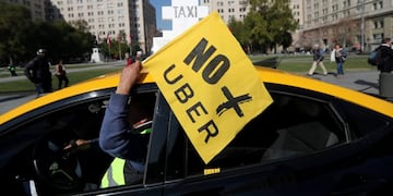 FILE PHOTO: A taxi driver holds a flag reading \