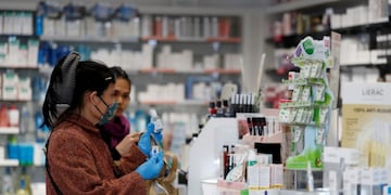 Women buy a homemade hand sanitiser at \