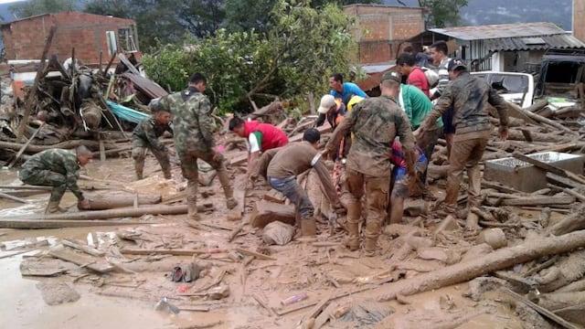 In this handout photo released by the Colombian National Army, soldiers and residents work together in rescue efforts in Mocoa, Colombia, Saturday, April 1, 2017, after an avalanche of water from an overflowing river swept through the city as people slept