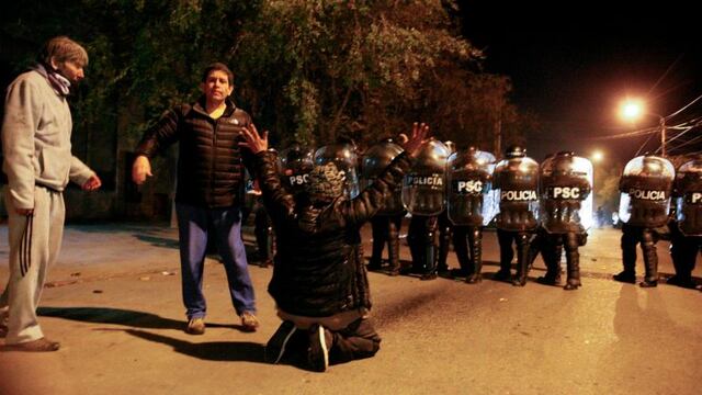 Un manifestante planta cara de rodillas a la policu00eda argentina el 22/04/2017 en la ciudad Ru00edo Gallegos, Argentina. Una protesta enu00a0la ciudad, en la provincia argentina de Santa Cruz, fue reprimida por la policu00eda cuandou00a0los manifestantes intentaron ingresar en la casa de la gobernadora, Alicia Kirchner, en la queu00a0tambiu00e9n estabau00a0la ex presidenta Cristina Fernu00e1ndez de Kirchner.rn(Vinculado al texto de dpa