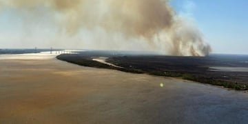 El denso humo cruzó el río durante la jornada debido al fuerte viento norte\u002E (@roylopezmolina)