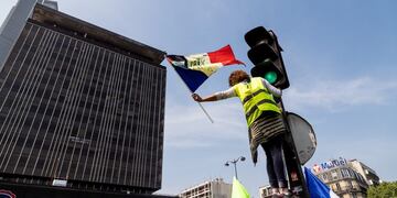 A yellow vest protester waves a French national flag on International Workers' Day in the Montparnasse district of Paris, France, on Wednesday, May 1, 2019\u002E French President Emmanuel Macron has called for an extremely firm response to violent protesters at Wednesday's traditional May 1 holiday demonstrations\u002E Photographer: Anita Pouchard Serra/Bloomberg