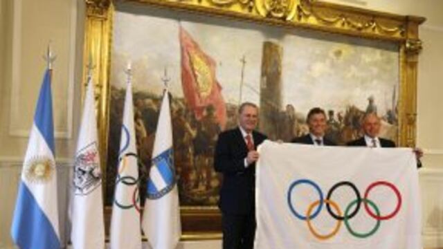 Jacqes Rogge (L), president of the International Olympic Commitee (IOC), Gerardo Werthein (R), president of the Argentine Olympic Committee, and Buenos Aires' Mayor Mauricio Macri hold an Olympic flag after a ceremony naming Rogge an