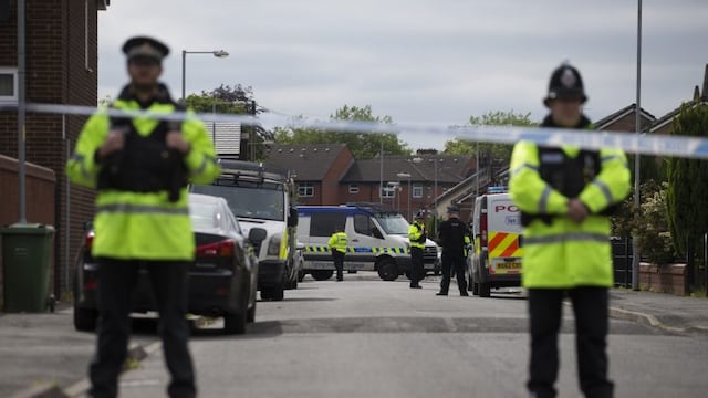 Police officers guard the entrance to a street in the Moss Side area of Manchester on May 28, 2017 during an operation.nA British minister said Sunday members of suicide bomber Salman Abedi's network could still be a large, as thousands defied the terror threat to take part in an annual half marathon. As runners pounded the streets of the northwestern English city, police arrested a 25-year-old man in the eastern Old Trafford area, bringing the number now detained on UK soil in connection with the attack to 12.n / AFP PHOTO / JOHN SUPER