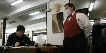 BAS06\u002E BUENOS AIRES (ARGENTINA) 01/07/09\u002E- Camareros del bar Don Bosco, del barrio de Almagro de Buenos Aires, atienden a los clientes protegidos con tapabocas hoy, 1 de julio de 2009, para prevenir la propagación de la gripe A\u002E Este martes se anunció que al menos otras dos personas murieron en ese país por el virus, con lo que suman 30 los fallecidos confirmados oficialmente, aunque los medios, con base en fuentes sanitarias oficiales de varios distritos, cifran entre 42 y 43 los fallecidos, a falta de datos actualizados del ministerio de Salud\u002E EFE/Leo La Valle buenos aires influenza gripe A h1n1 prevencion barbijos medidas de prevencion contagio mosos con barbijo