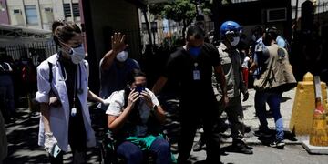 A patient is carried on a wheelchair during a fire at the federal hospital of Bonsucesso in the north zone of Rio de Janeiro, Brazil, October 27, 2020\u002E REUTERS/Ricardo Moraes