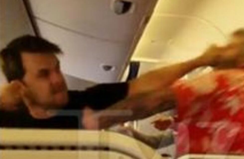 Dos pasajeros a las piñas en medio de un avión