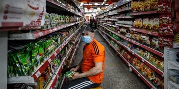 Un trabajador de un supermercado usa tapabocas\u002E (EFE)