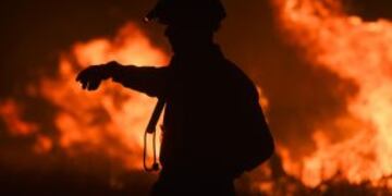 A fireman gestures while fighting a wildfire near La Adela in La Pampa Province on January 5, 2017. nFirefighters in Argentina said on January 5 they were bringing under control three wildfires that have devastated nearly a million hectares (2.5 million acres) of the country's famous pampas, or plains. / AFP PHOTO / Eitan ABRAMOVICH