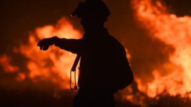 A fireman gestures while fighting a wildfire near La Adela in La Pampa Province on January 5, 2017. nFirefighters in Argentina said on January 5 they were bringing under control three wildfires that have devastated nearly a million hectares (2.5 million acres) of the country's famous pampas, or plains. / AFP PHOTO / Eitan ABRAMOVICH