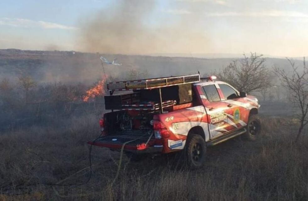 Bomberos combaten un incendio forestal en un barrio de Cosquín