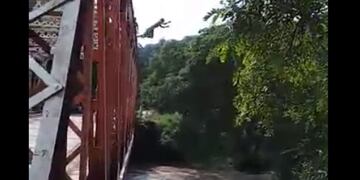 Video: adolescentes saltan desde un puente de hierro en plena crecida del río Loro\u002E (Captura)