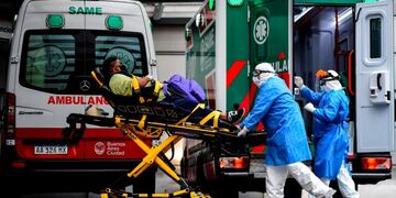 Argentine doctors Gonzalo Figueroa (R) and Hernan Chaile of the Medical Emergency System (SAME) of Buenos Aires move a patient with COVID-19 symptoms to a hospital in Buenos Aires, on May 20, 2020\u002E - The number of COVID-19 cases in Argentina has raised to more than 9\u002E000, while the mandatory quarantine imposed on March 20 is still fully applied in the capital Buenos Aires\u002E (Photo by RONALDO SCHEMIDT / AFP) coronavirus test casos del dia laboratorio testeos PCR HISOPADO ambulancia