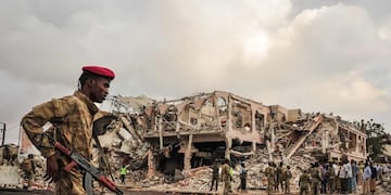 TOPSHOT - EDITORS NOTE: Graphic content / Somali soldiers patrol on the scene of the explosion of a truck bomb in the centre of Mogadishu, on October 15, 2017\u002E\nA truck bomb exploded outside a hotel at a busy junction in Somalia's capital Mogadishu on October 14, 2017 causing widespread devastation that left at least 20 dead, with the toll likely to rise\u002E / AFP PHOTO / Mohamed ABDIWAHAB