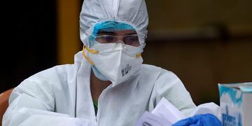 A medical representative prepares to collect swab samples from residents to test for the Covid-19 Coronavirus, in a residential area in Mumbai, on September 14, 2020\u002E (Photo by Punit PARANJPE / AFP)