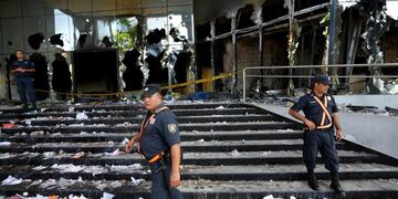 Police officers guard the Congress entrance in Asuncion, Paraguay, Saturday, April 1, 2017. Protesters stormed Paraguay's Congress building Friday night, setting it on fire after a secret Senate vote to approve a bill that would allow President Horacio Cartes to run for another term. (AP Photo/Jorge Saenz)