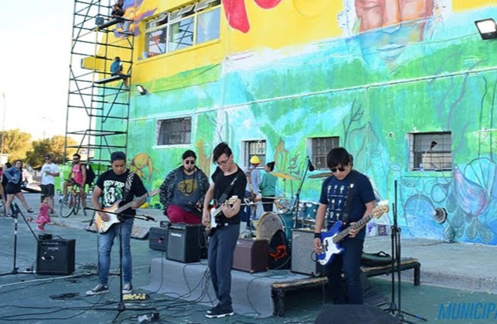 Artistas realizan un mural en el Complejo Deportivo Municipal