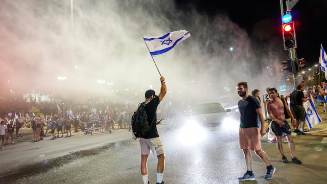 La policía israelí emplea un cañón de agua para dispersar a manifestantes que bloquean una calle en una protesta contra los planes del gobierno del primer ministro, Benjamin Netanyahu,  de reformar el sistema judicial, en Jerusalén, el domingo 23 de julio de 2023. Foto: AP / Ohad Zwigenberg.