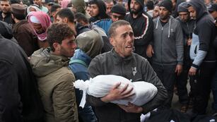 Un palestino sostiene el cuerpo de un niño muerto en los bombardeos israelíes en la Franja de Gaza, en Deir al Balah, el 23 de febrero de 2024.