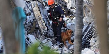 Bomberos y rescatistas buscan personas desaparecidas bajo los escombros, tras el derrumbe parcial de un edificio en Surfside, Miami.