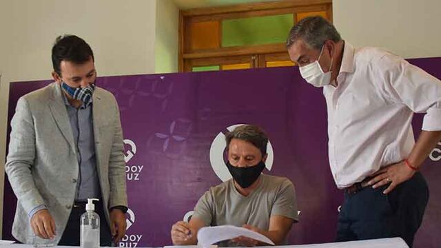 El intendente de Godoy Cruz García Zalazar y el ministro Vaquié observan la firma de uno de los adherentes al programa Mendoza Activa. Gentileza Municipalidad de Godoy Cruz