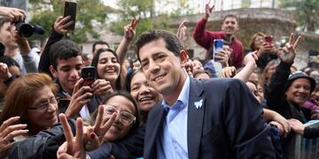 El ministro de Interior de Argentina, Eduardo 'Wado' de Pedro, posa con simpatizantes en Quilmes, Buenos Aires, Argentina, el lunes 22 de mayo de 2023. De Pedro lanzó su campaña para postularse como candidato presidencial del oficialismo. (AP Foto/Joaquín Salguero)