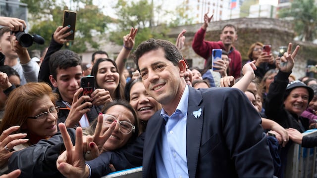 El ministro de Interior de Argentina, Eduardo 'Wado' de Pedro, posa con simpatizantes en Quilmes, Buenos Aires, Argentina, el lunes 22 de mayo de 2023. De Pedro lanzó su campaña para postularse como candidato presidencial del oficialismo. (AP Foto/Joaquín Salguero)
