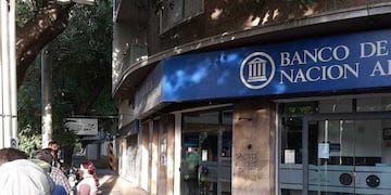 Trabajadores estatales hacen fila para cobrar sus salarios.