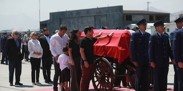 Hijos de Piñera junto al féretro, de fondo el presidente Boric.