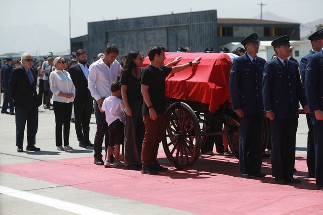 Hijos de Piñera junto al féretro, de fondo el presidente Boric.