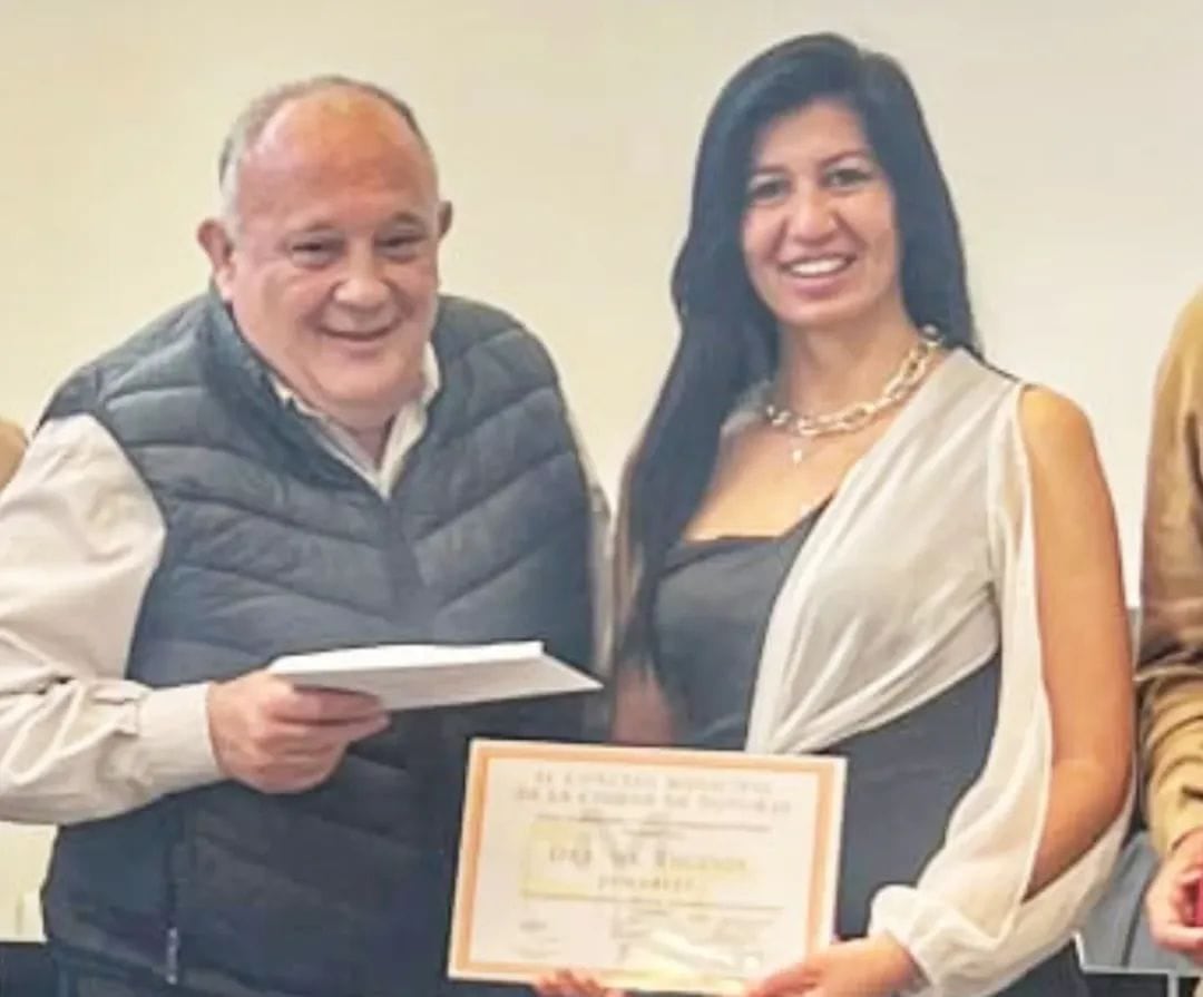 La autora del libro “Ultrajada Cuna Jujeña”, María Eugenia Jamarlli, recibe de manos del concejal José Manuel Pascual una copia de la declaración y un diploma honorífico.