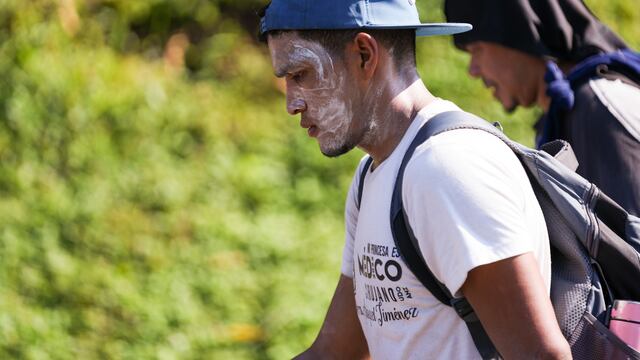 Un migrante con protector solar en el rostro camina sobre la carretera en Escuintla, en el sur de México, en su odisea hacia la frontera norte del país y con destino a Estados Unidos, el jueves 7 de noviembre de 2024. (AP Foto/Moisés Castillo)