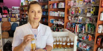 Guadalupe Ñañez en su farmacia y con su repelente de elaboración propia.