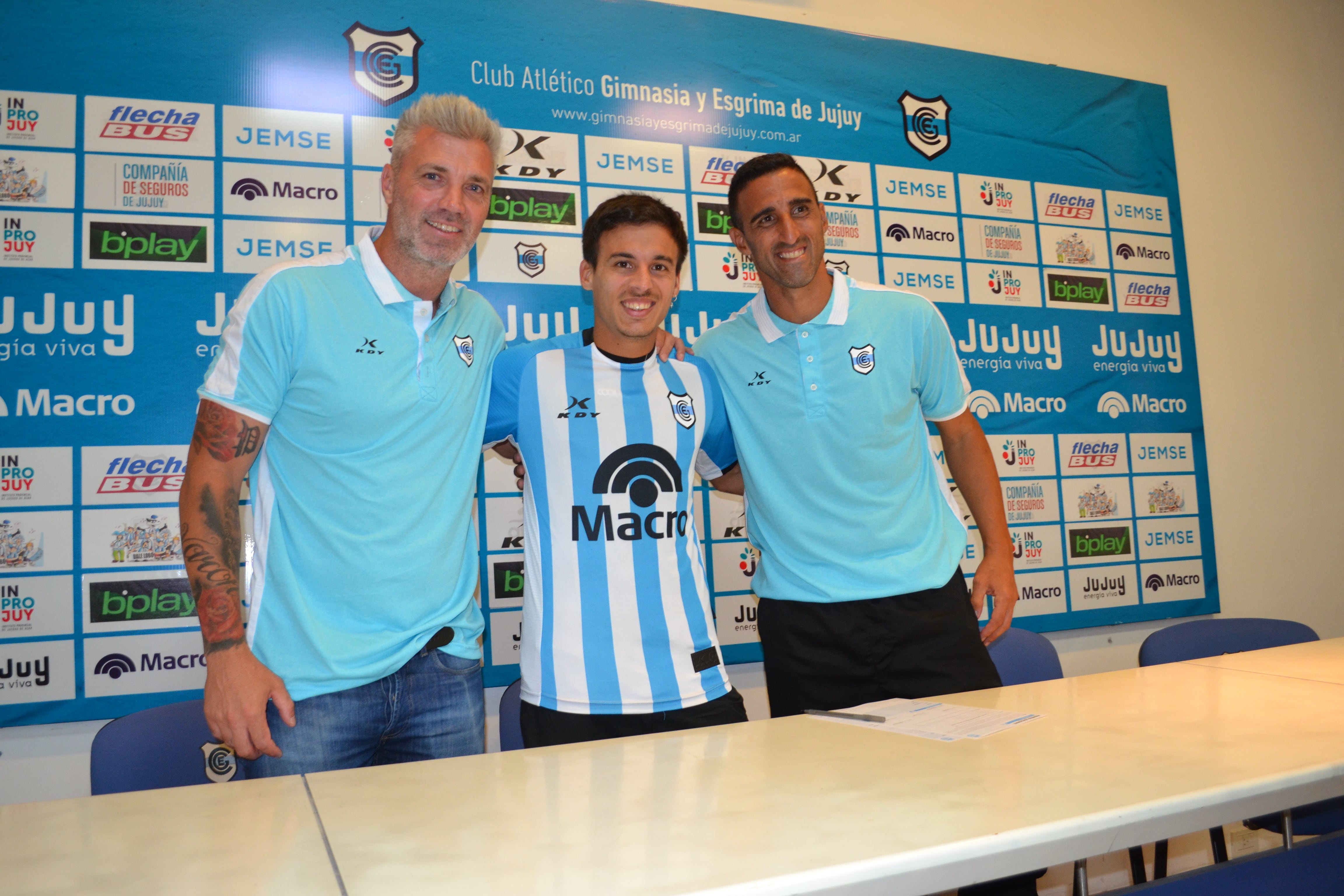 El volante Claudio Pombo fue el primer refuerzo incorporado para el plantel 2026 de Gimnasia de Jujuy. Le dieron la bienvenida el manager deportivo del club, Julio Chiarini (izq.), y el  DT Hernán Pellerano.