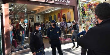Inspectores municipales y policía hacen bajar las percianas a comerciantes del área peatonal en la ciudad de Córdoba. (Pedro Castillo/ La Voz)