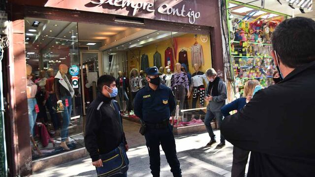 Inspectores municipales y policía hacen bajar las percianas a comerciantes del área peatonal en la ciudad de Córdoba. (Pedro Castillo/ La Voz)