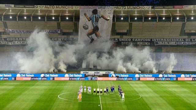 Los jugadores de Talleres y Boca formando una M inmortal. Con telón de fondo.