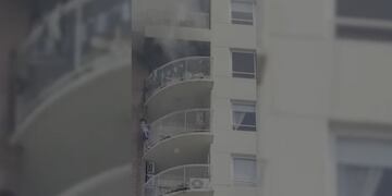 El nene colgado en la parte de afuera del balcón, para tratar de huir de las llamas del departamento.