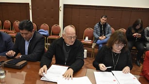 El padre Germán Maccagno (centro) y la diputada Mariela Ortiz repasan documentación referida al Santuario de Río Blanco, que podría ser declarado Patrimonio Provincial.