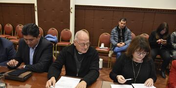 El padre Germán Maccagno (centro) y la diputada Mariela Ortiz repasan documentación referida al Santuario de Río Blanco, que podría ser declarado Patrimonio Provincial.